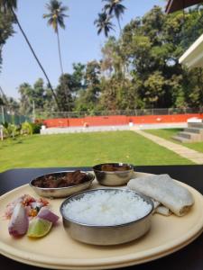 a tray with three bowls of food on a table at Sk Resort in Alibaug