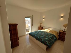 - une chambre avec un lit et une porte donnant sur une terrasse dans l'établissement Apartamento Mimosas, à Albufeira