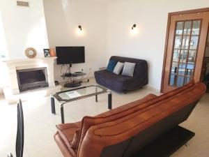 - un salon avec un canapé et une télévision dans l'établissement Apartamento Mimosas, à Albufeira