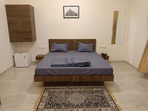 1 dormitorio con 1 cama grande con sábanas azules y alfombra en Sk Resort en Alibaug