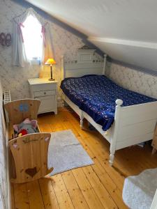 1 dormitorio con 1 cama, 1 silla y 1 ventana en Grellsbo, en Grebbestad