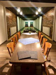 Hotel am Wasserfall في لينغن: قاعة المؤتمرات مع طاولة وكراسي طويلة