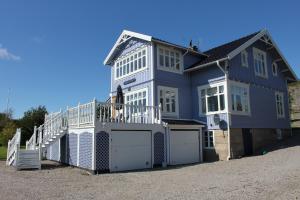 una casa azul y blanca con garaje en Grellsbo en Grebbestad