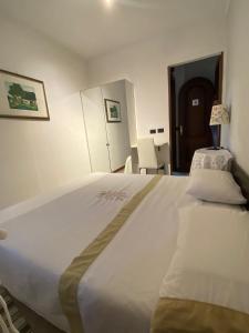 a large white bed in a room with a door at L'angolo di Chiavari in Chiavari +2 photos