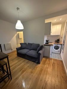 a living room with a couch and a kitchen at LE COSY de Saint-Denis in Saint-Denis