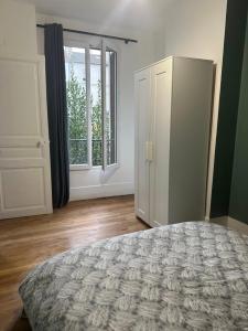 a bedroom with a bed and a large window at LE COSY de Saint-Denis in Saint-Denis