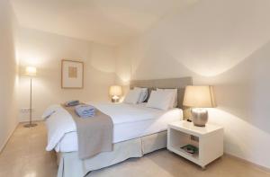 a bedroom with a large white bed and a night stand at Guesthouse Palma - Suite Arabella Apartment, Adults Only in Palma de Mallorca