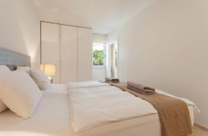 a white bedroom with a bed with towels on it at Guesthouse Palma - Suite Arabella Apartment, Adults Only in Palma de Mallorca