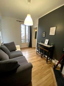 a living room with a couch and a piano at LE COSY de Saint-Denis in Saint-Denis