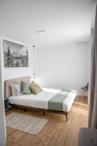 Dormitorio blanco con cama con almohadas en Mountain Lodge en Rîşnov