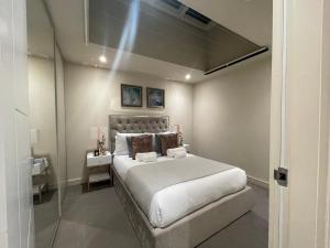 um quarto com uma grande cama branca num quarto em Sophisticated 1BR, 1 BA Chigwell Designer Flat CHCL F2 em Chigwell
