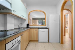 a kitchen with a white refrigerator and a sink at Costa Linda 201 in Hospitalet de l'Infant