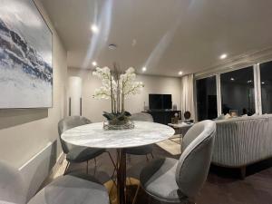 uma sala de jantar com mesa e cadeiras em Sophisticated 1BR, 1 BA Chigwell Designer Flat CHCL F2 em Chigwell