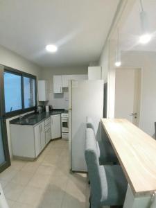 cocina con nevera y mesa. en Amplio Departamento 2 Dormitorios Nueva Córdoba en Córdoba