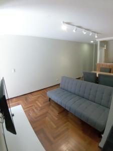 sala de estar con sofá azul y mesa en Amplio Departamento 2 Dormitorios Nueva Córdoba en Córdoba