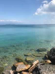 a view of the ocean with rocks in the water at Antonella Gardalake 2 in Desenzano del Garda