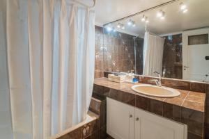 a bathroom with a sink and a mirror at Sea Front Luxury Apartment in Patra