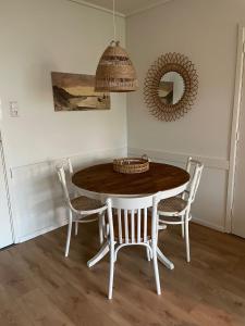 a dining room table with chairs and a mirror at Appartement Dishoek No.46 in Koudekerke