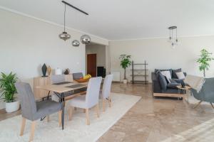 a living room with a table and chairs and a couch at Sea Front Luxury Apartment in Patra +11 photos
