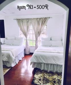 two beds in a room with a window at PRIME GUEST HOUSE in Boksburg