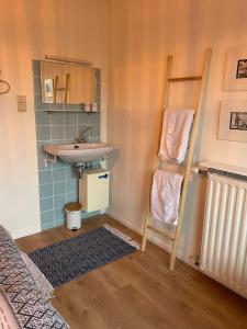 un baño con lavabo y una escalera junto a un lavabo en Appartement Dishoek No.46, en Koudekerke