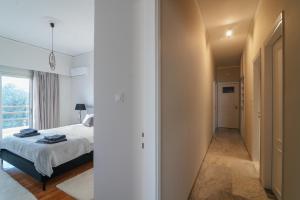 a bedroom with a bed and a hallway with a window at Sea Front Luxury Apartment in Patra