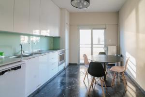 a kitchen with a table and chairs and a sink at Sea Front Luxury Apartment in Patra