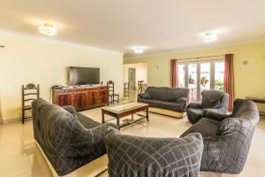 a living room with couches and a flat screen tv at Villa Quinta da Marinha II in Cascais