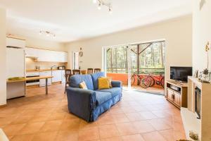 sala de estar con sofá azul y cocina en Apartment Anibal, en Aroeira