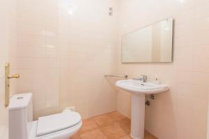 a white bathroom with a toilet and a sink at Apartment Anibal in Aroeira +11 photos