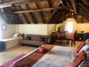 a room with two beds and a couch and a table at Waterberg Accommodation in Modimolle