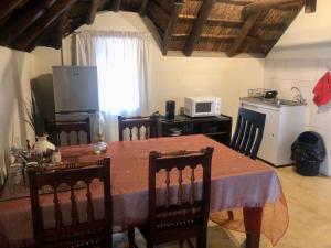a kitchen with a table with chairs and a microwave at Waterberg Accommodation in Modimolle