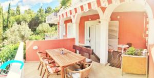an outdoor patio with a wooden table and chairs at Villa Kipre 2 in Cavtat
