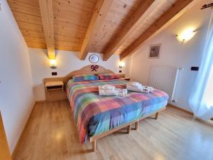 una camera con un grande letto e un soffitto in legno di Residence Le Rose a Pozza di Fassa