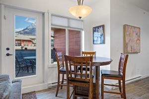 a dining room with a table and chairs and a window at Mountain Retreat - Modern and Bright with Panorama Views 2 bedrooms, 4 beds, heated all-year outdoor pool, hottub, balcony, Banff Park Pass in Canmore