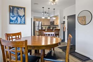 a dining room and kitchen with a wooden table and chairs at Mountain Retreat - Modern and Bright with Panorama Views 2 bedrooms, 4 beds, heated all-year outdoor pool, hottub, balcony, Banff Park Pass in Canmore