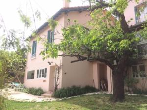 a pink house with a tree in front of it at Gîte Autour du figuier in Palaldo