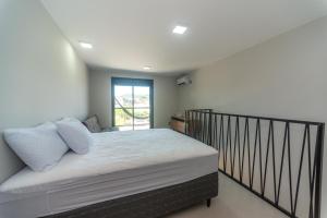 a bedroom with a bed with a black railing at Pousada Soul Papagaio - lofts completos a 30 metros do mar in Palhoça