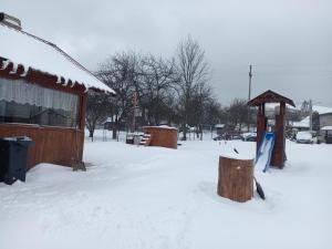 eine schneebedeckte Straße mit einem Gebäude und einem Pavillon in der Unterkunft Casa Paty in Kloster Humor