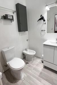 a white bathroom with a toilet and a sink at En Palencia capital céntrico con garaje Roberto in Palencia