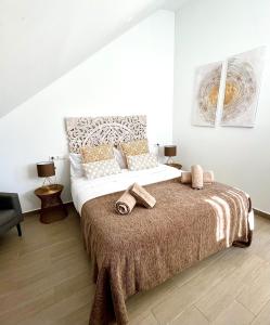 a bedroom with a large bed with towels on it at Hostal El Caprichito Marbella in Marbella