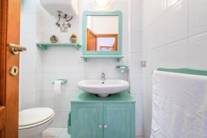 łazienka z błękitną umywalką i toaletą w obiekcie AffittaSardegna-CASA SERSE w mieście Stintino
