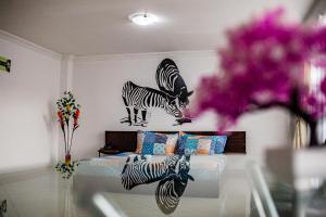 a bedroom with a bed with two zebras on the wall at Hotel Zaclordy in Ubaté
