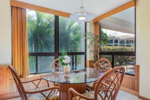 een eetkamer met een glazen tafel en stoelen en een groot raam bij Shores at Waikoloa #108 in Waikoloa