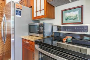 a kitchen with a stove and a microwave at Shores at Waikoloa #108 in Waikoloa