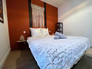 a bedroom with a large bed with a white comforter at Le Triplex Terracotta in Nantes