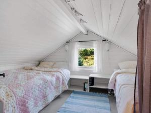 1 dormitorio con 2 camas y ventana en Holiday home TORANGSVÅG II, en Skår