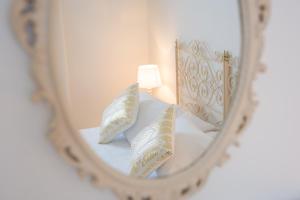 a mirror reflection of a lamp on a bed at Hotel La Pineta Al Mare in Forte dei Marmi