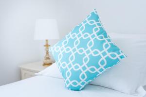 a blue and white pillow sitting on top of a bed at Hotel La Pineta Al Mare in Forte dei Marmi