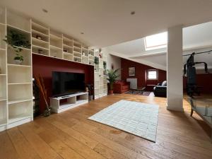 a living room with a flat screen tv and a large living room at Le Triplex Terracotta in Nantes
